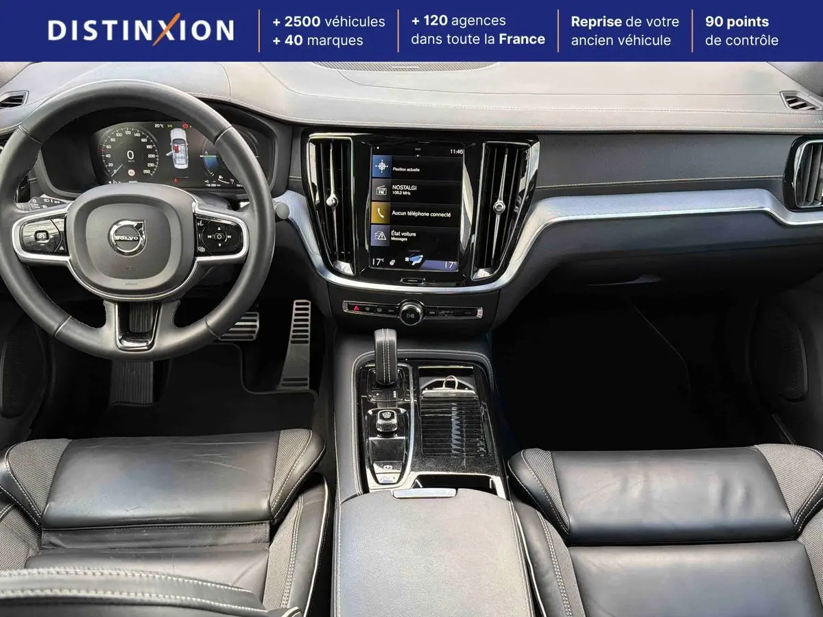 Vue intérieure avant de la Volvo S60 T8 2021, tableau de bord noir avec écran tactile central et volant cuir multifonctions.