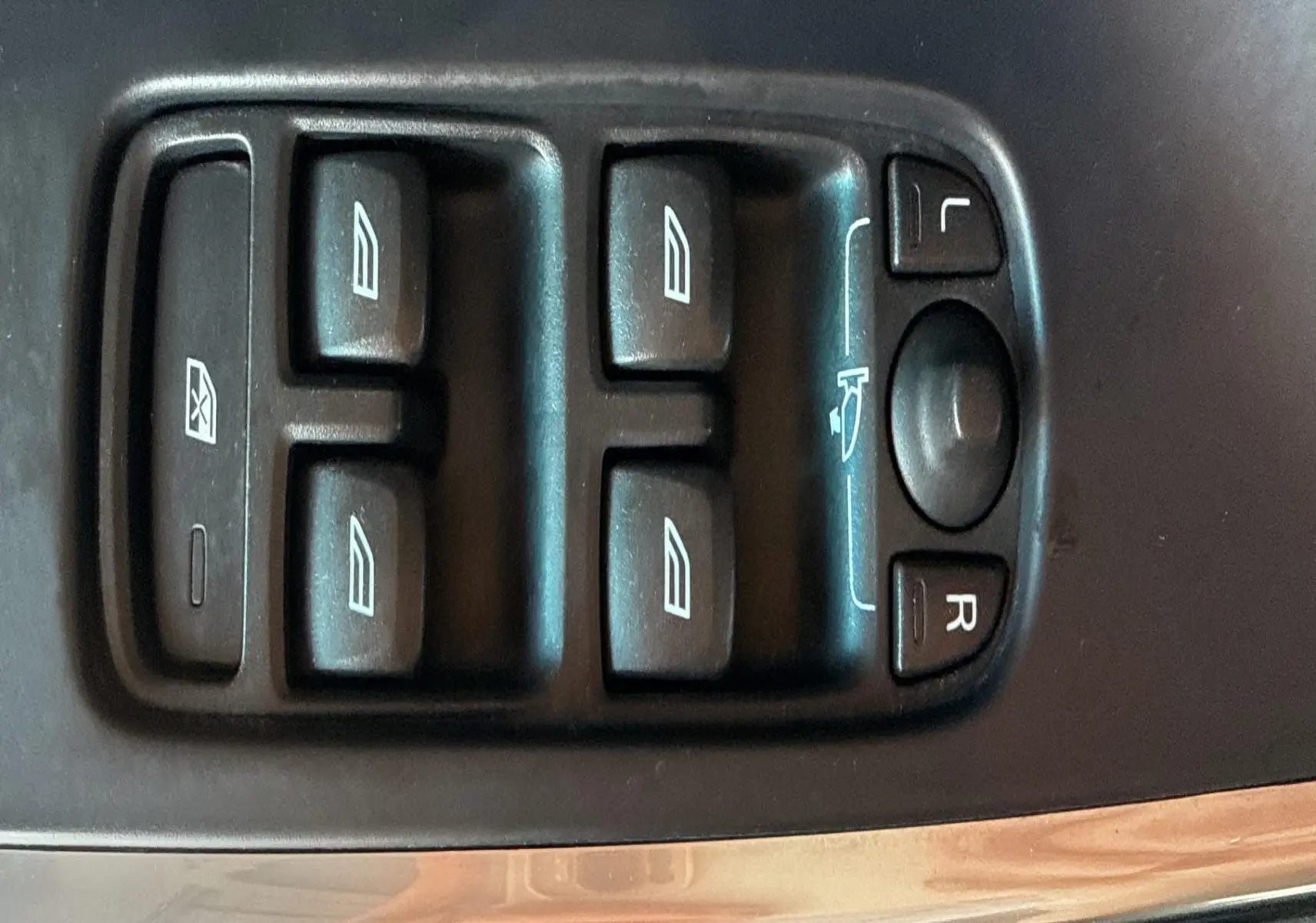 Panneau de commandes des vitres et rétroviseurs côté conducteur d'un Volvo XC60 gris 2016, vue rapprochée.