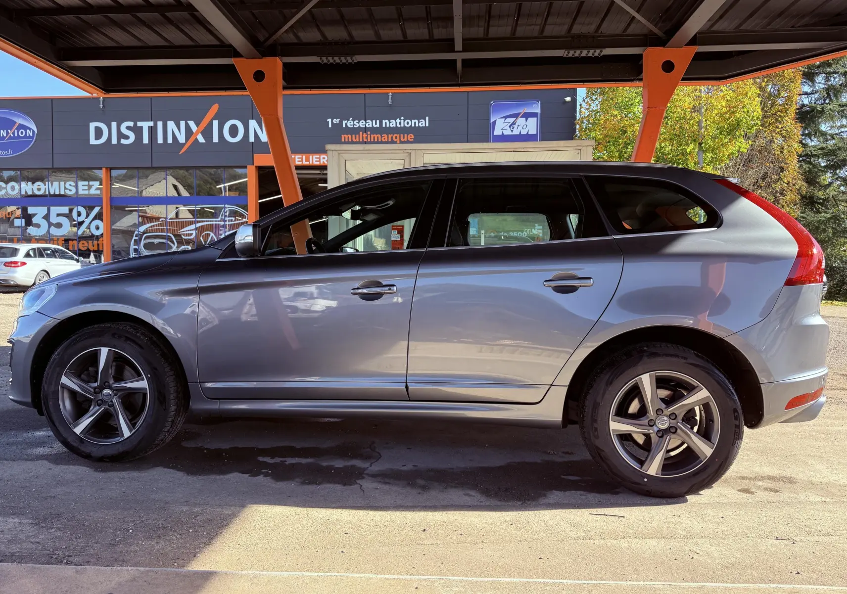 Profil côté gauche du Volvo XC60 gris 2016, version D4 Momentum avec jantes alliage et vitres teintées.