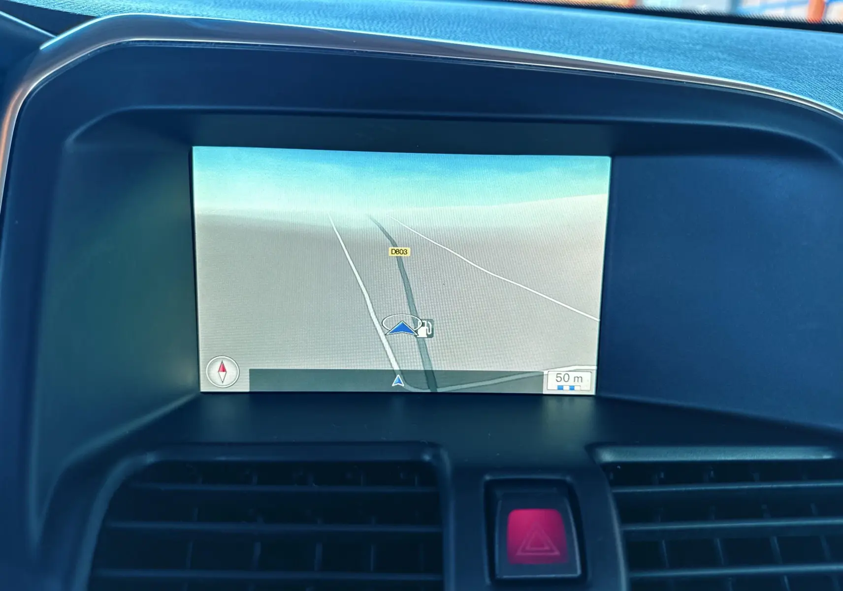 Écran de navigation intégré au tableau de bord du Volvo XC60 gris 2016, affichant une carte routière simple.