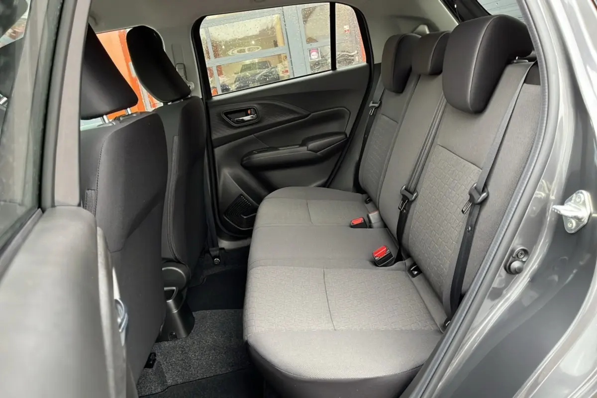 Vue côté droit de la banquette arrière grise en tissu d'une Suzuki Swift 2025 Mineral grey metal avec ceinture et appuie-têtes.