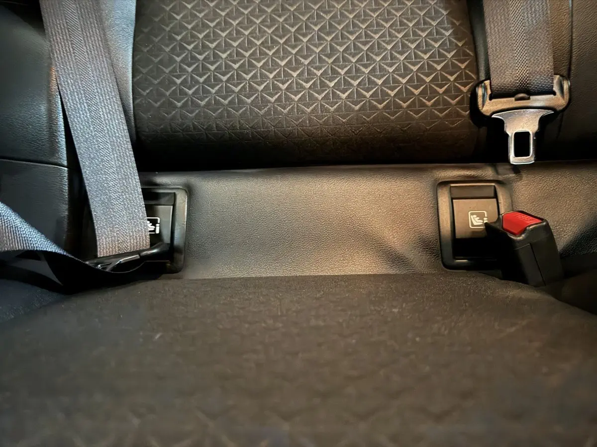 Gros plan sur la banquette arrière noire du Nissan Juke 2025 avec ceintures de sécurité et fixations Isofix visibles.