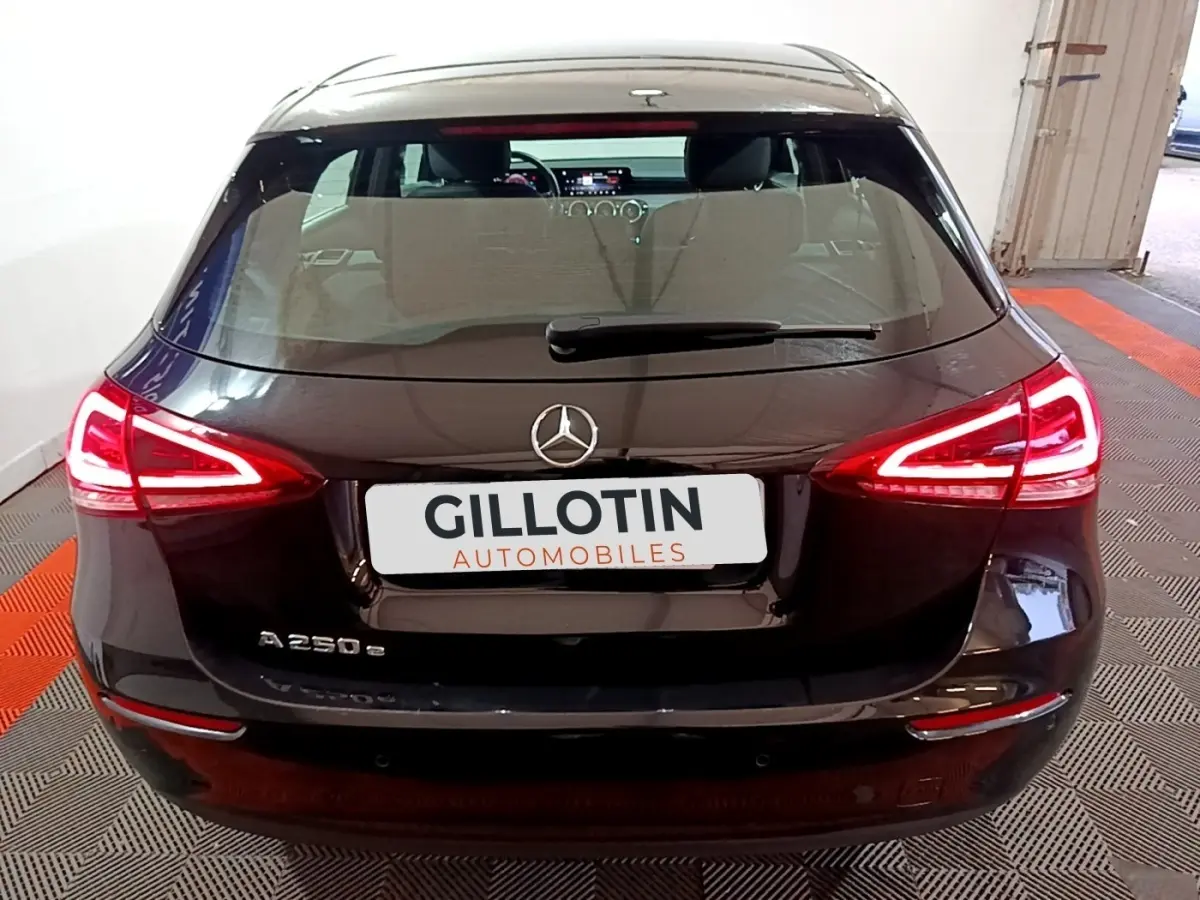 Vue arrière d'une Mercedes Classe A 250 e Business Line noire avec feux LED allumés en intérieur.