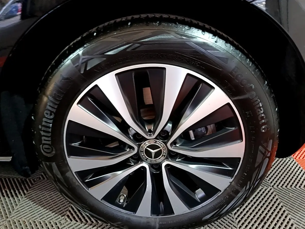 Gros plan sur la jante alliage bicolore et pneu Continental d'une Mercedes Classe A noire, version A 250 e Business Line.