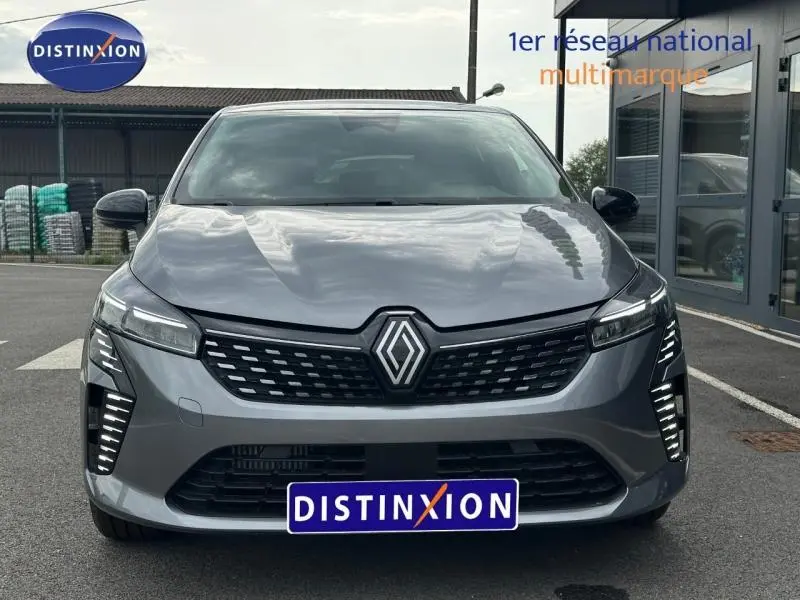 Vue avant d'une Renault Clio 2025 gris Rafale avec calandre noire et feux LED verticaux allumés.