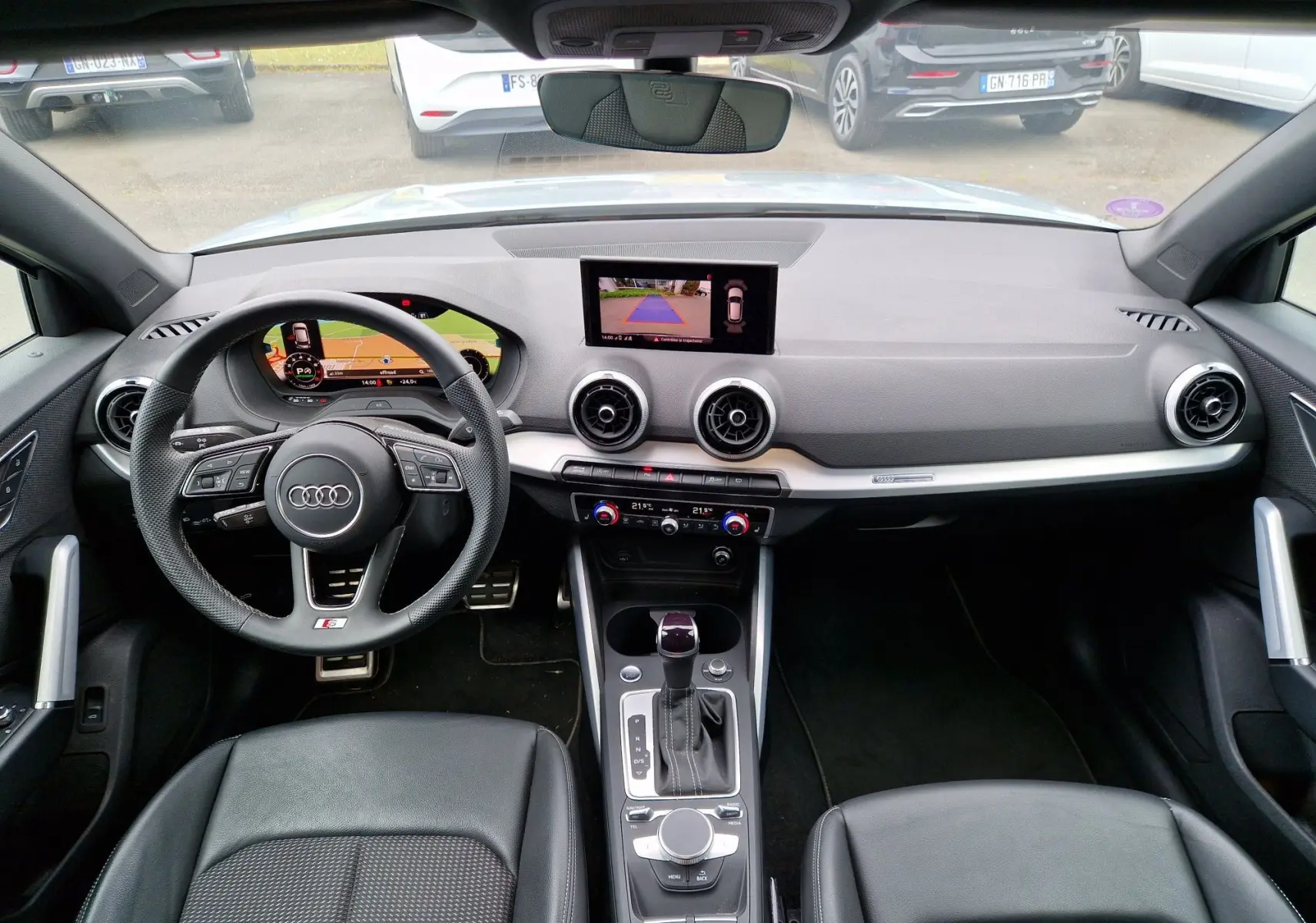 Vue intérieure frontale de l'Audi Q2 35 TFSI 2023 gris flèche, avec tableau de bord S line et écran MMI navigation.