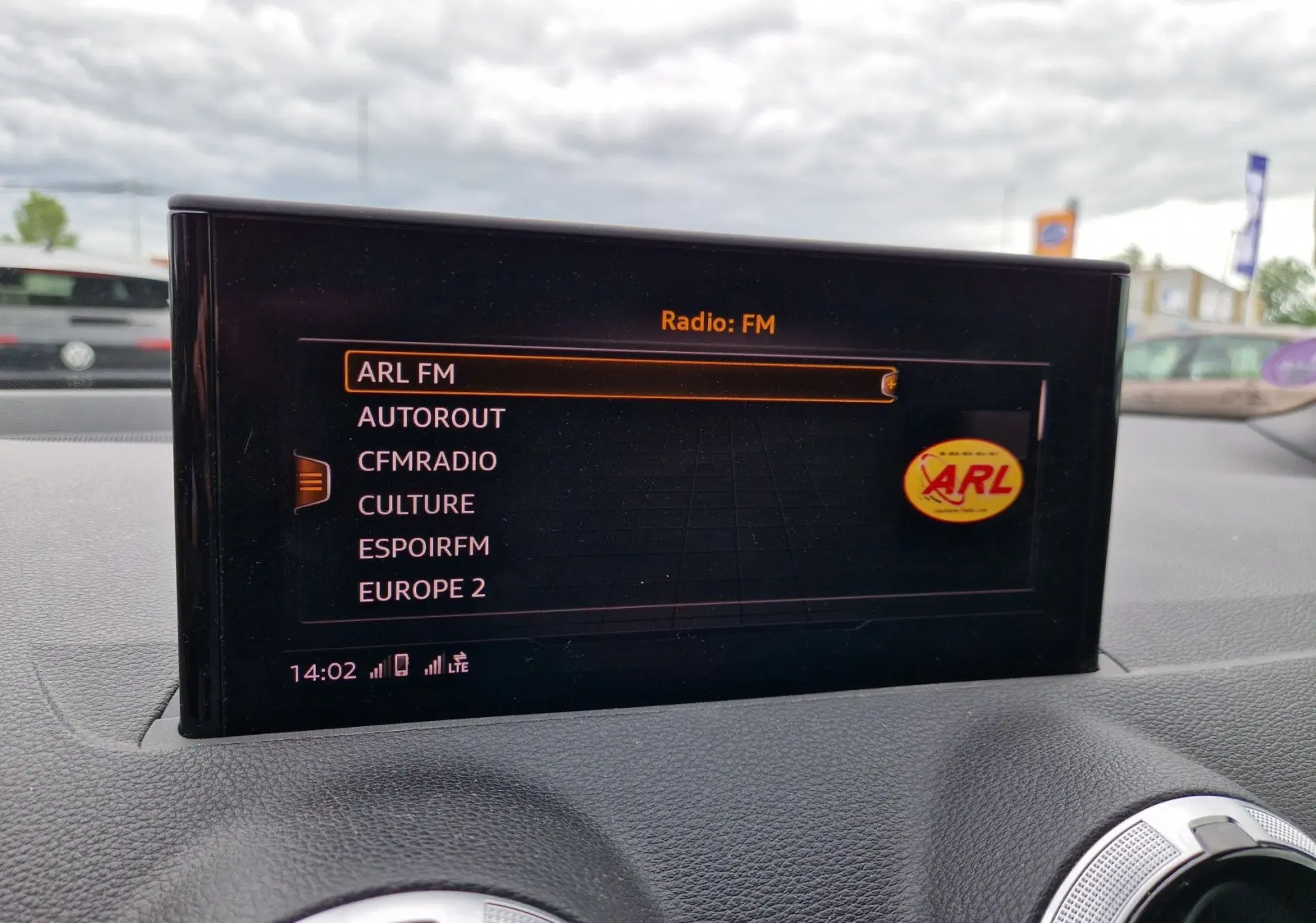 Écran central MMI navigation affichant les stations FM dans l’Audi Q2 35 TFSI gris flèche, vue intérieure avant.