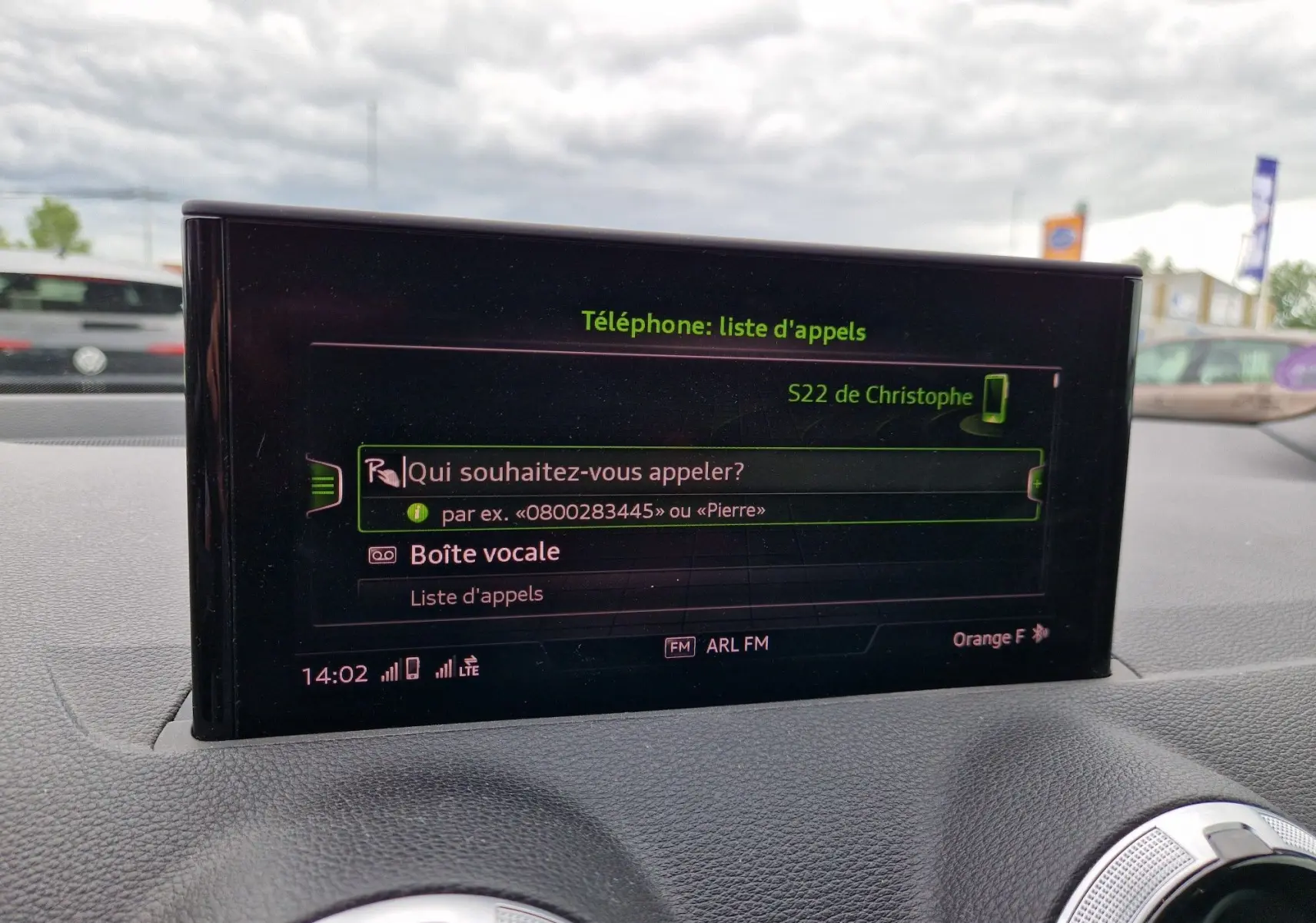 Écran central MMI tactile de l'Audi Q2 35 TFSI 2023 affichant la liste d'appels, intérieur gris et aluminium brossé.