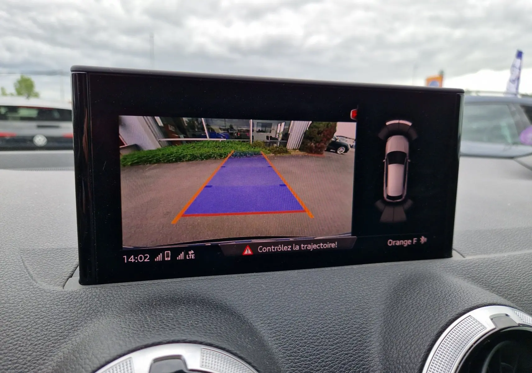 Écran de l’Audi Q2 35 TFSI 2023 montrant la caméra de recul avec guidage de trajectoire en bleu et orange.
