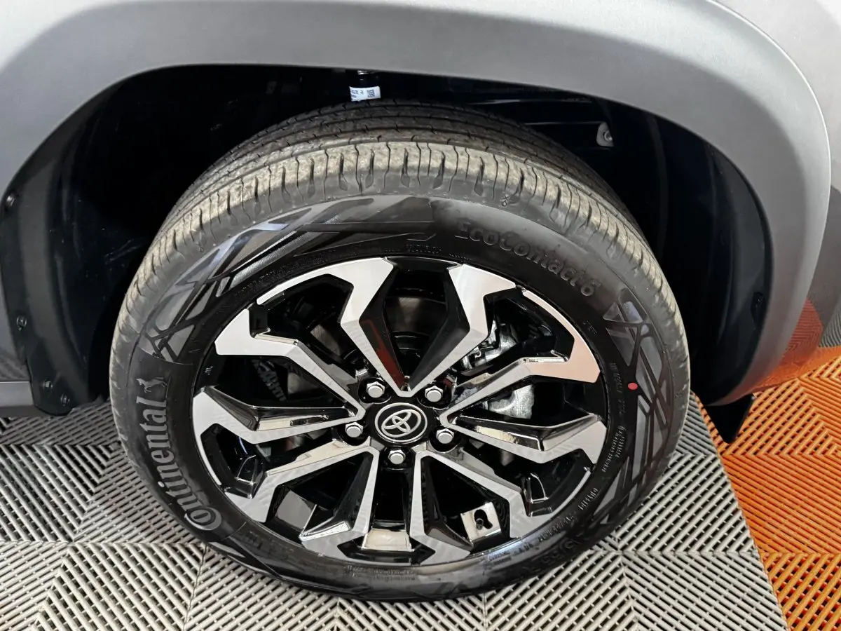 Gros plan sur la roue avant droite de la Toyota Yaris Cross 2026, jante alliage noire et argentée avec logo Toyota central.