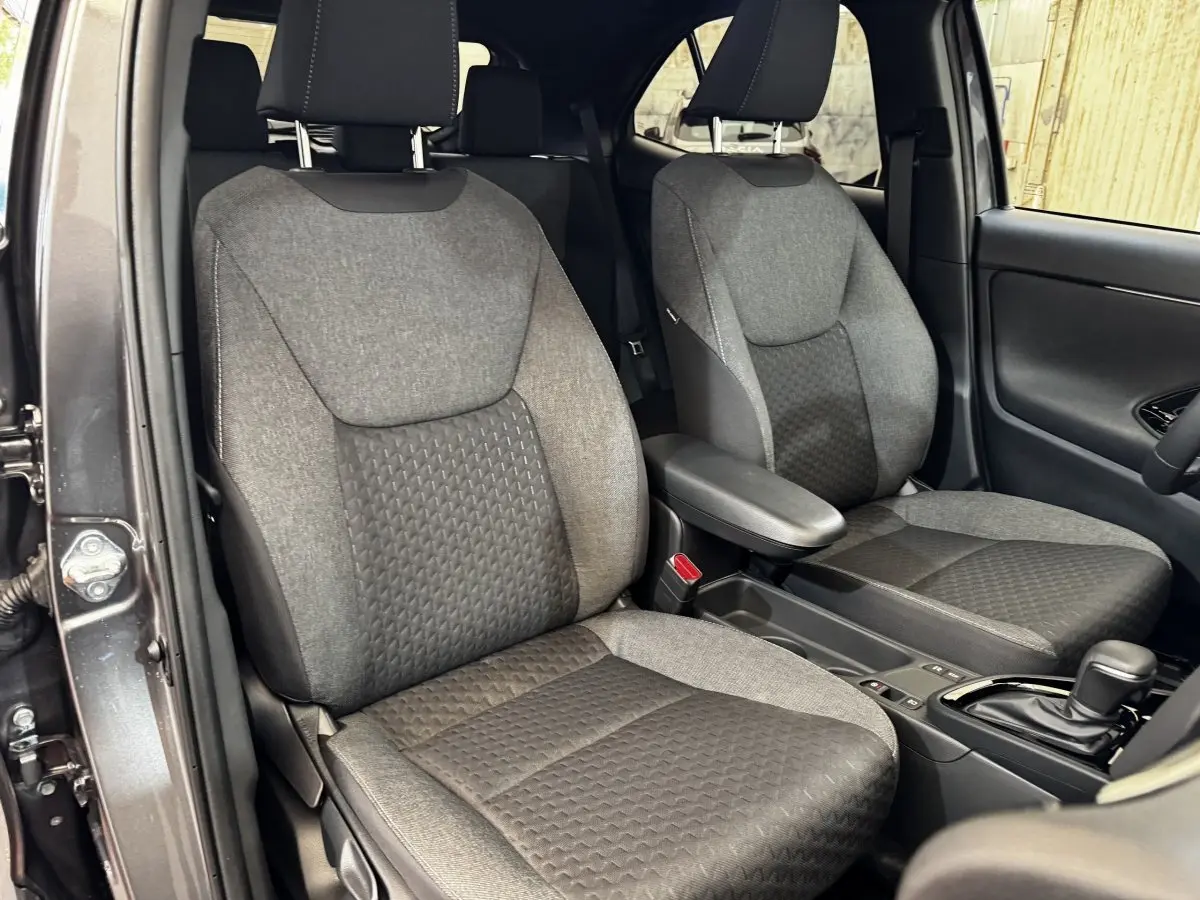 Vue intérieure côté avant droit de la Toyota Yaris Cross 2026, sièges tissu gris et console centrale avec boîte auto.