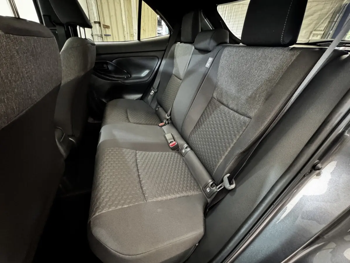 Vue intérieure côté droit sur la banquette arrière gris foncé de la Toyota Yaris Cross 1.5 Hybrid 130h Design Auto 2026.