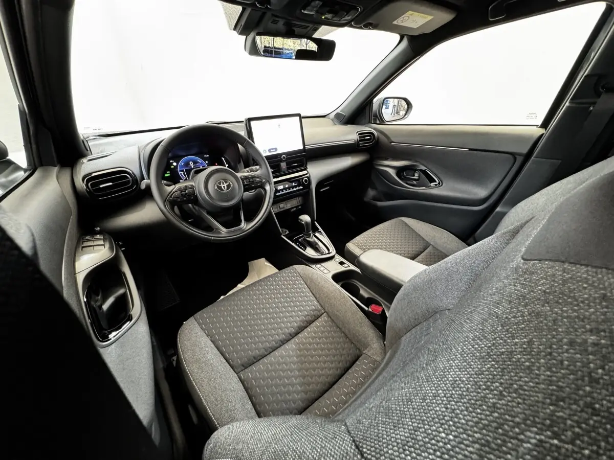 Vue intérieure côté conducteur de la Toyota Yaris Cross 2026, volant cuir multifonctions et écran tactile central.