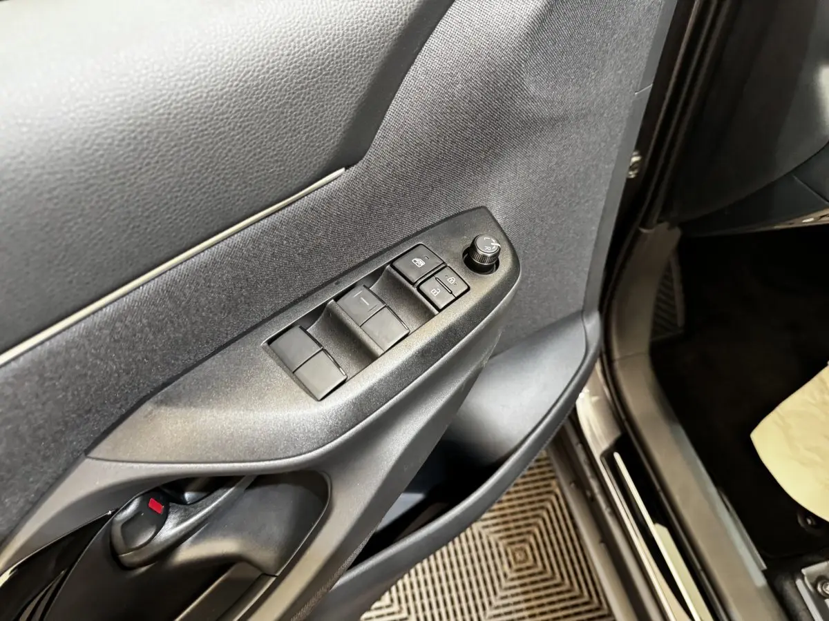 Gros plan sur la porte côté conducteur de la Toyota Yaris Cross 2026, montrant les commandes des vitres et rétroviseurs.