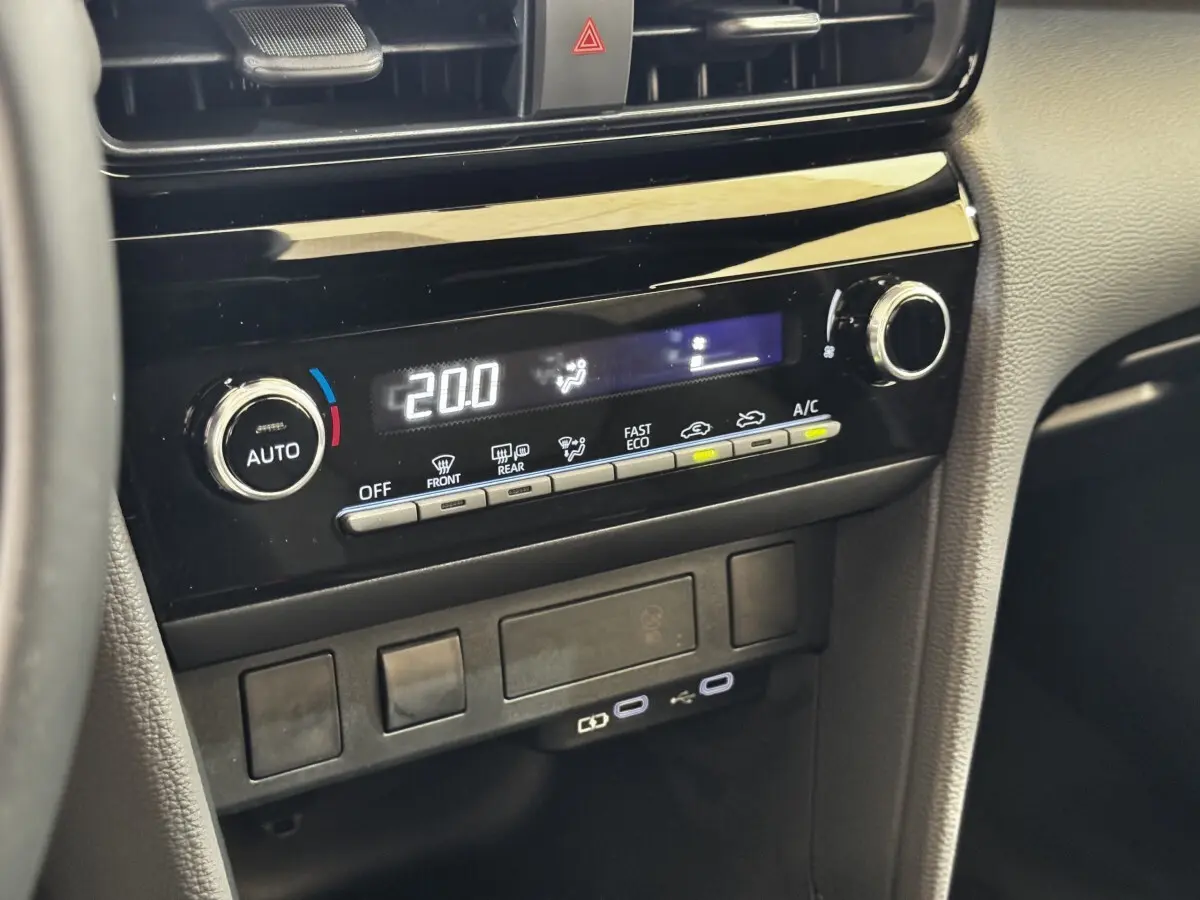 Vue rapprochée de la console centrale noire de la Toyota Yaris Cross 2026 avec commandes climatisation et ports USB visibles.