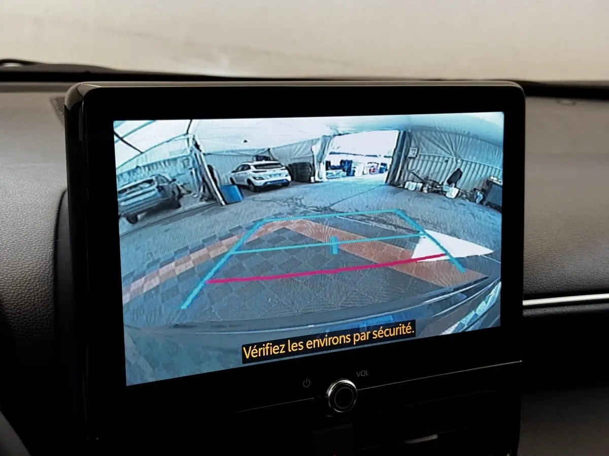 Écran tactile central montrant la caméra de recul du Toyota Yaris Cross 2026 dans un garage lumineux.