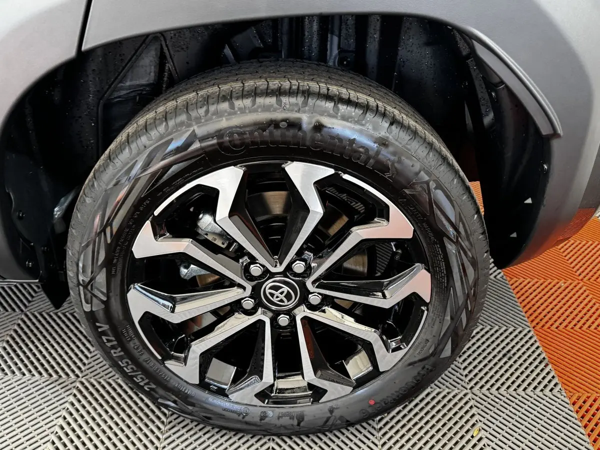 Gros plan sur la roue avant droite du Toyota Yaris Cross 2026 gris foncé avec jante alliage noire et argentée.