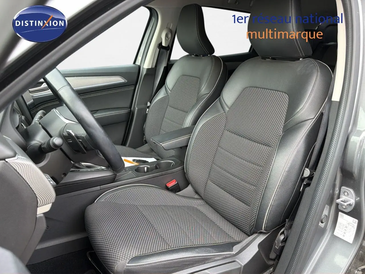 Vue intérieure côté conducteur de la Renault Arkana gris 2022, sièges en cuir noir avec surpiqûres contrastées.