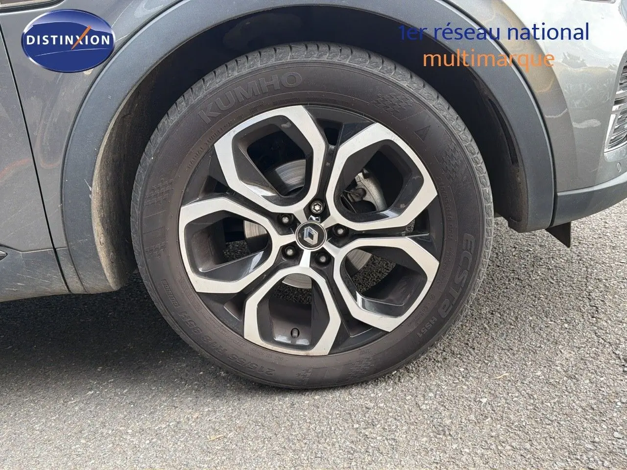 Gros plan sur la roue avant droite d'un Renault Arkana gris 2022 avec jante alliage bicolore et pneu Kumho.