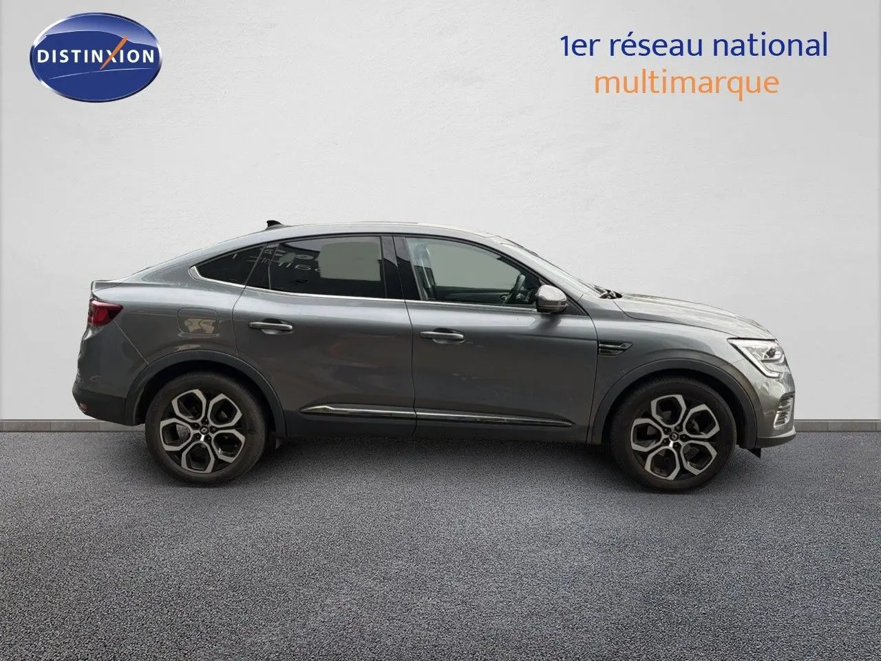 Profil droit d'un Renault Arkana gris 2022 avec jantes alliage bi-ton et lignes fluides de SUV coupé.