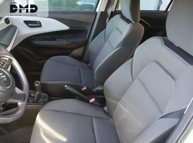 Vue intérieure côté gauche de la Suzuki Swift 1.2 Privilège Hybrid 2024, sièges tissu gris et volant cuir noir.