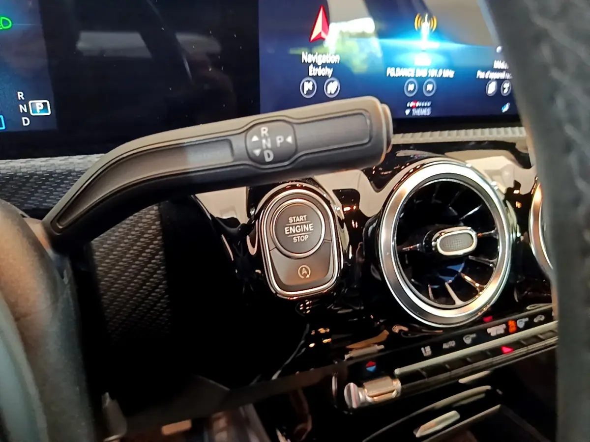 Gros plan sur le tableau de bord de la Mercedes Classe A 180 d Business Line 2020, avec bouton Start/Stop et aérateur rond.