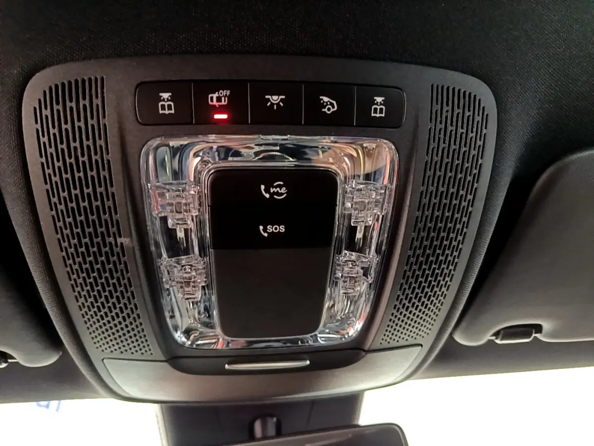 Vue en gros plan du plafonnier noir avec boutons SOS et appels dans une Mercedes Classe A gris clair 2020.