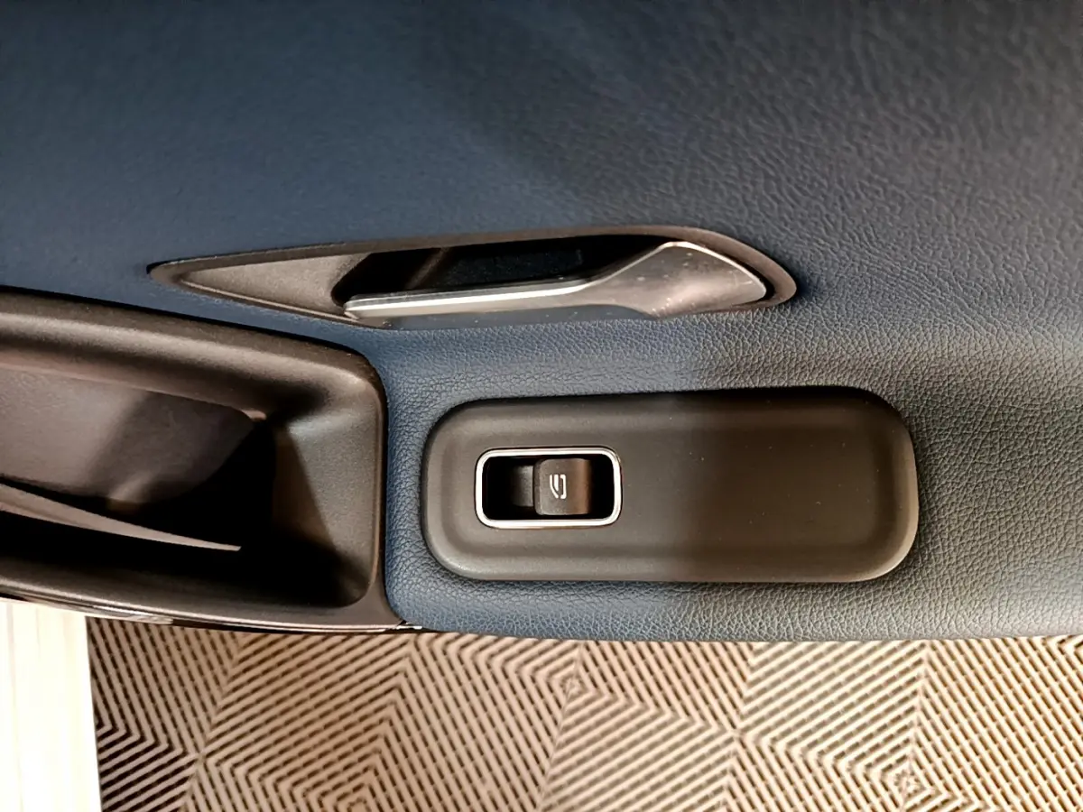 Détail de la commande de lève-vitre sur la porte intérieure côté conducteur d’une Mercedes Classe A gris clair.