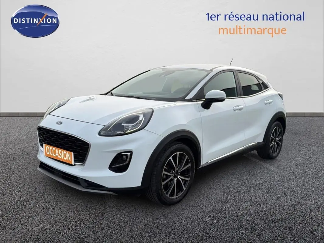 Ford Puma blanc en 3/4 avant droit, avec jantes alliage noires et vitres surteintées visibles.