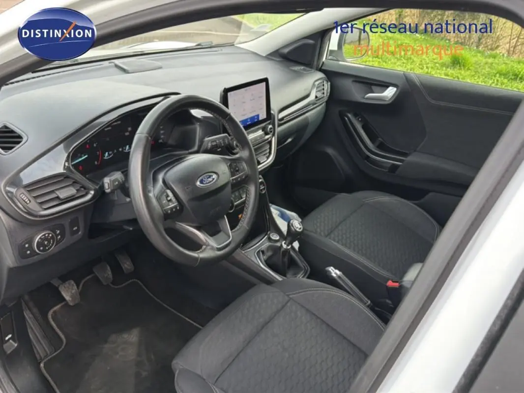 Vue intérieure côté conducteur du Ford Puma blanc 2020, avec tableau de bord moderne et écran tactile central.