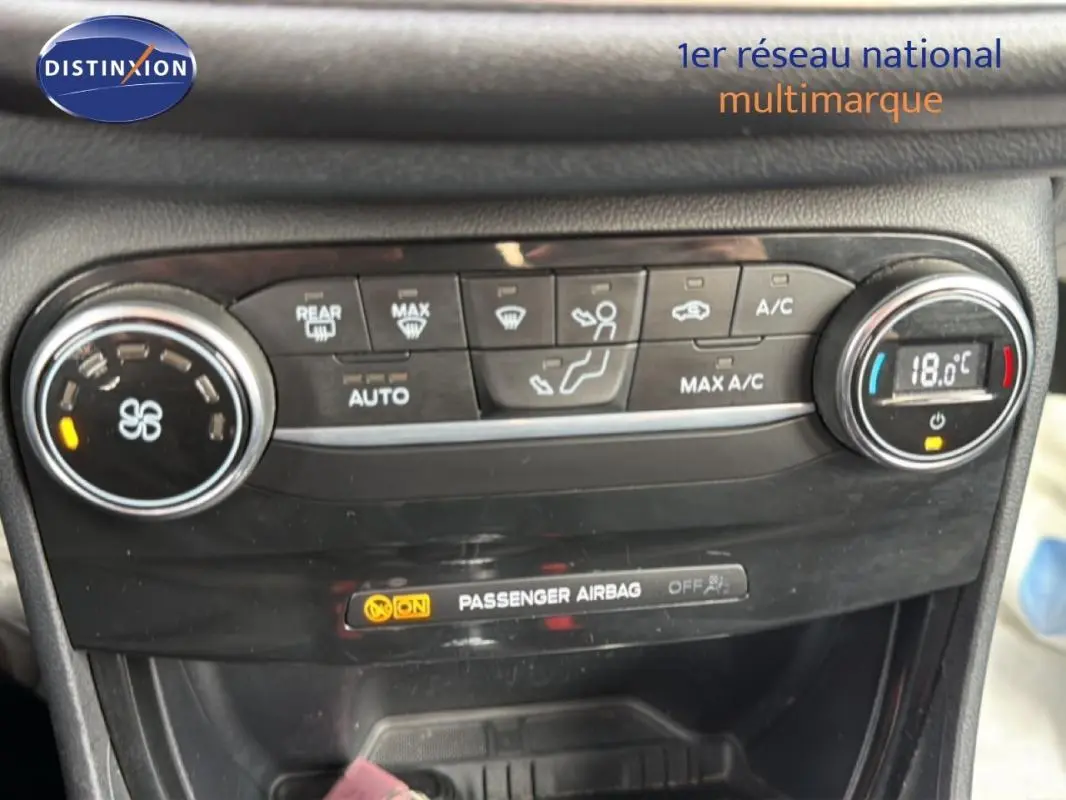 Gros plan sur la console de climatisation noire du Ford Puma blanc, affichant 18°C et commandes tactiles.