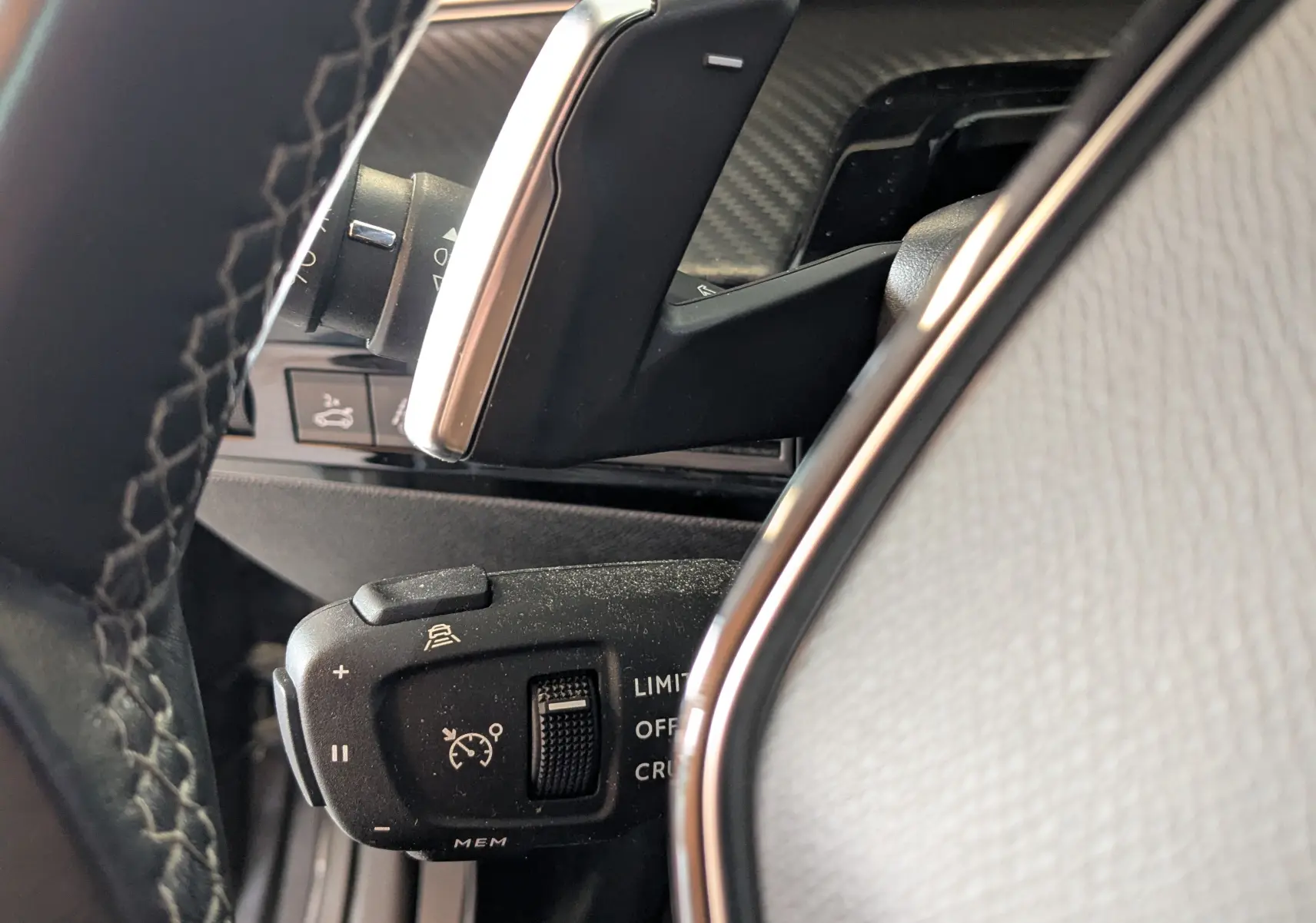 Gros plan sur la commande de régulateur de vitesse au volant d’une Peugeot 508 SW 1.5 dCi gris, intérieur noir et argent.
