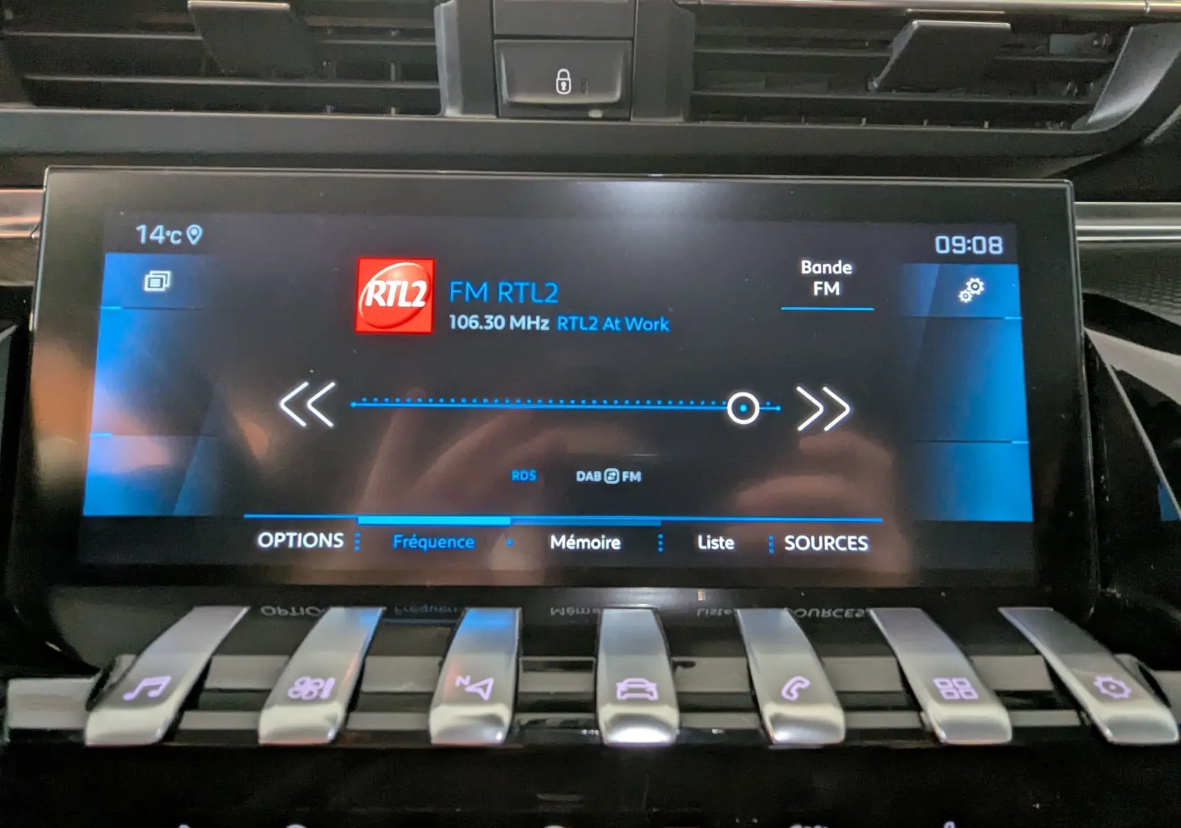 Écran tactile central de la Peugeot 508 SW gris, affichant la radio FM RTL2 à 09:08 avec commandes piano en dessous.