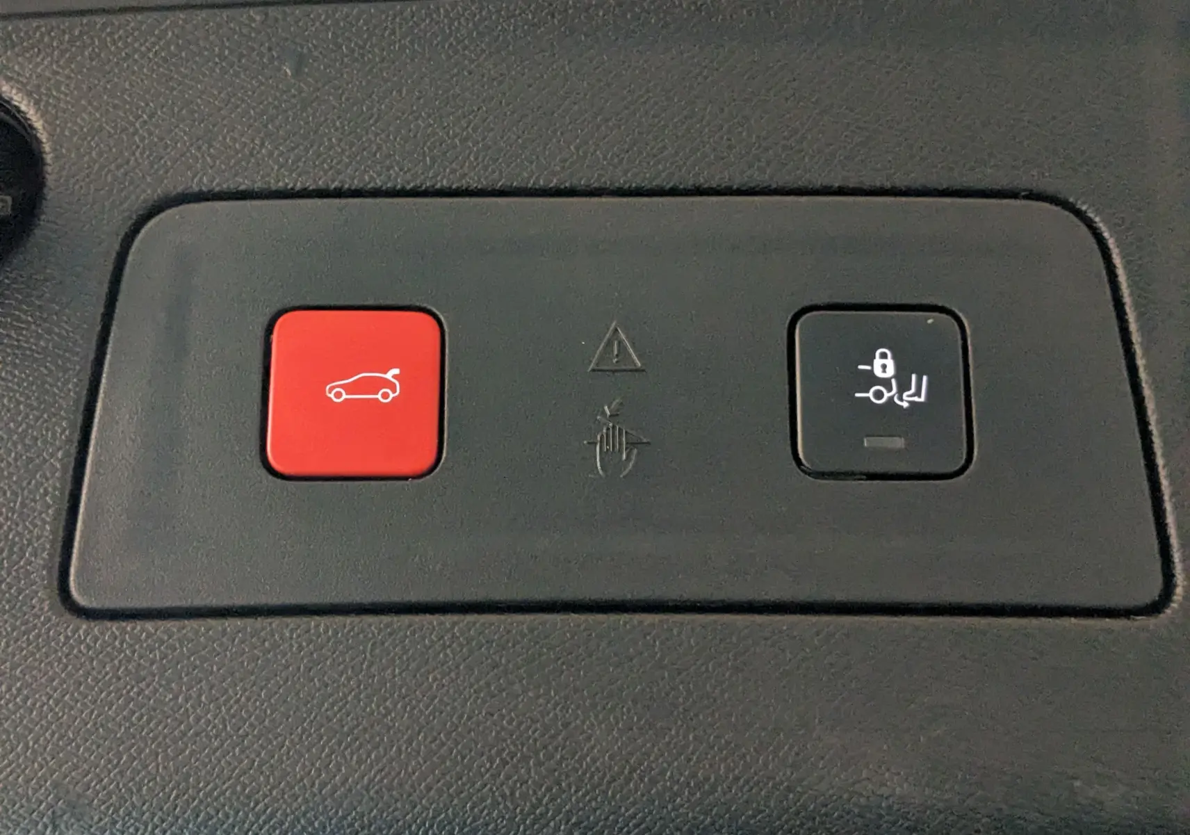 Gros plan sur les boutons de commande du hayon électrique et du verrouillage des sièges dans une Peugeot 508 SW gris 2021.