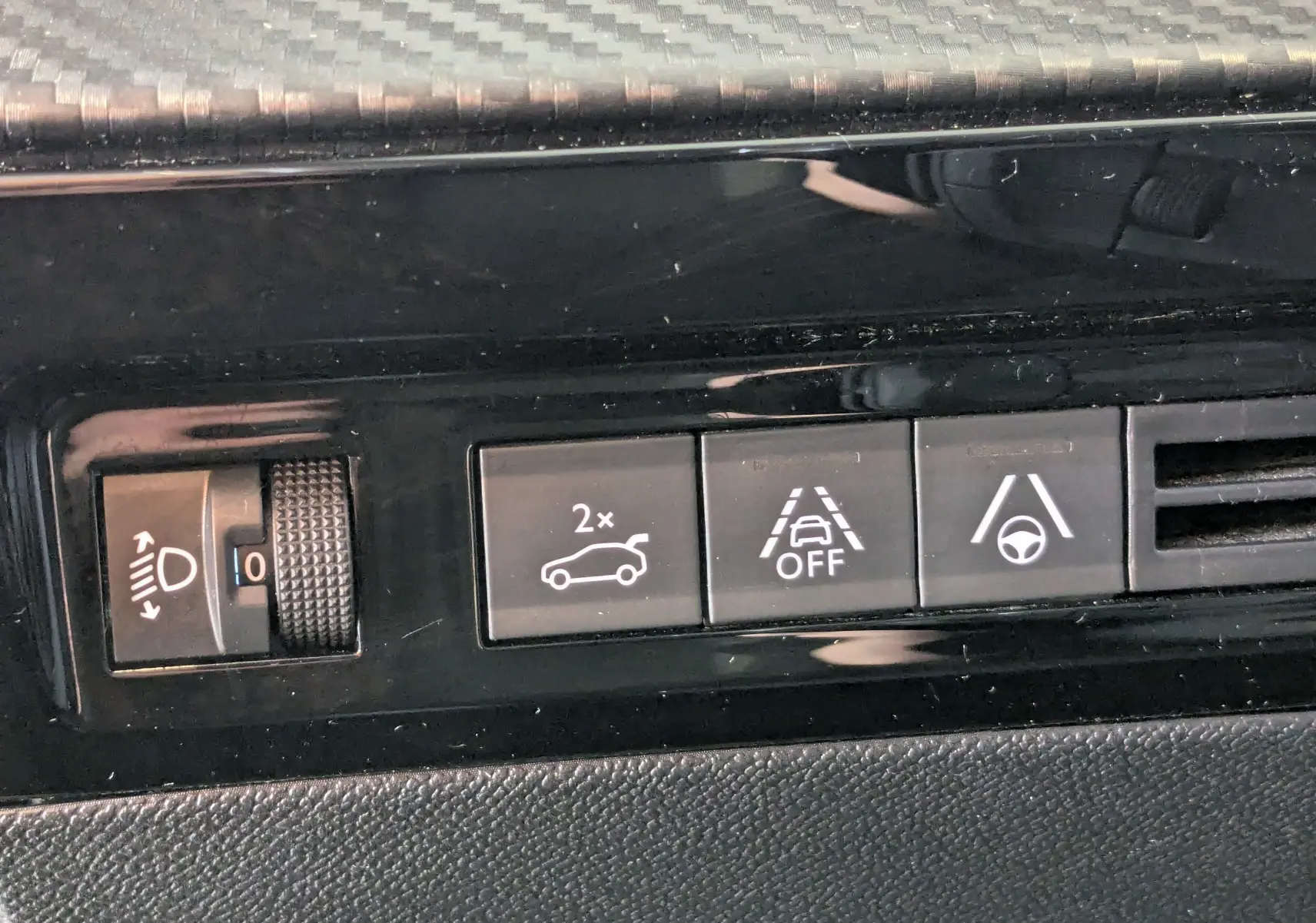 Gros plan sur les boutons de commande intérieurs noirs du tableau de bord d'une Peugeot 508 SW gris 2021.