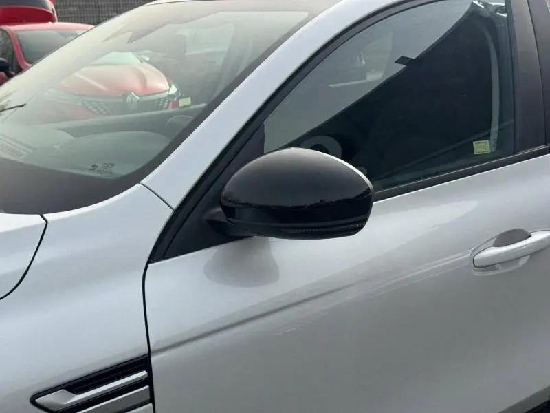 Gros plan sur le rétroviseur noir et la portière blanche côté gauche d’un Renault Arkana 2025 hybride essence.