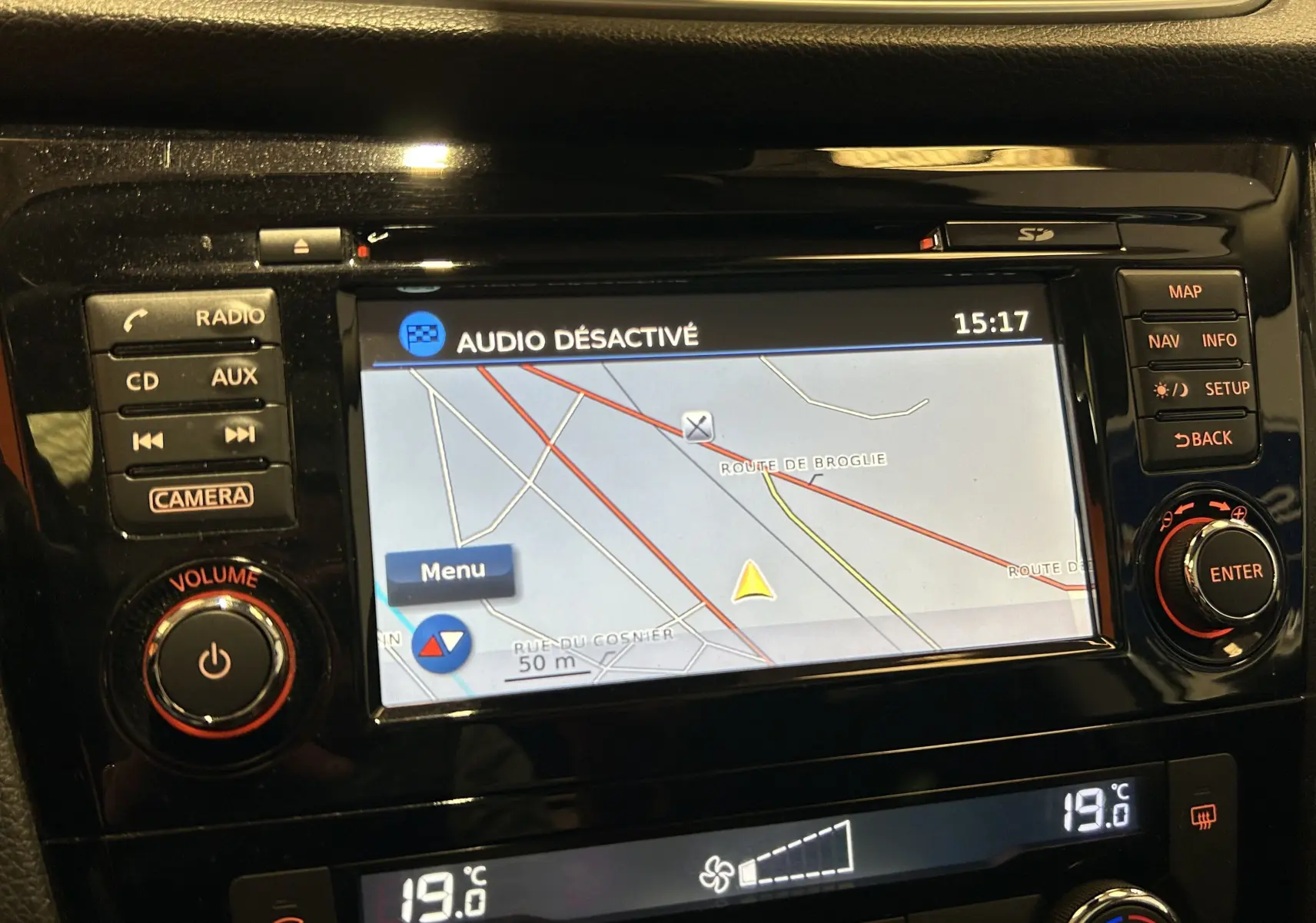 Écran central du tableau de bord du Nissan Qashqai 2018 montrant la navigation GPS et les commandes autour en noir brillant.