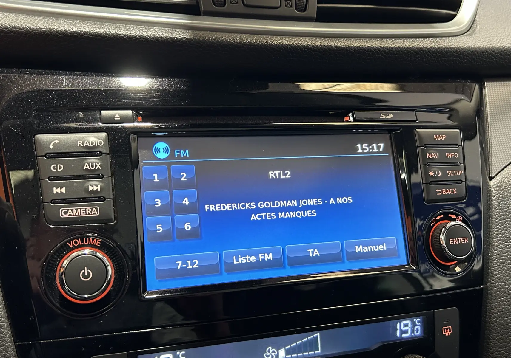Gros plan sur l’écran central multimédia du Nissan Qashqai blanc, affichant la radio FM RTL2 à 15h17.