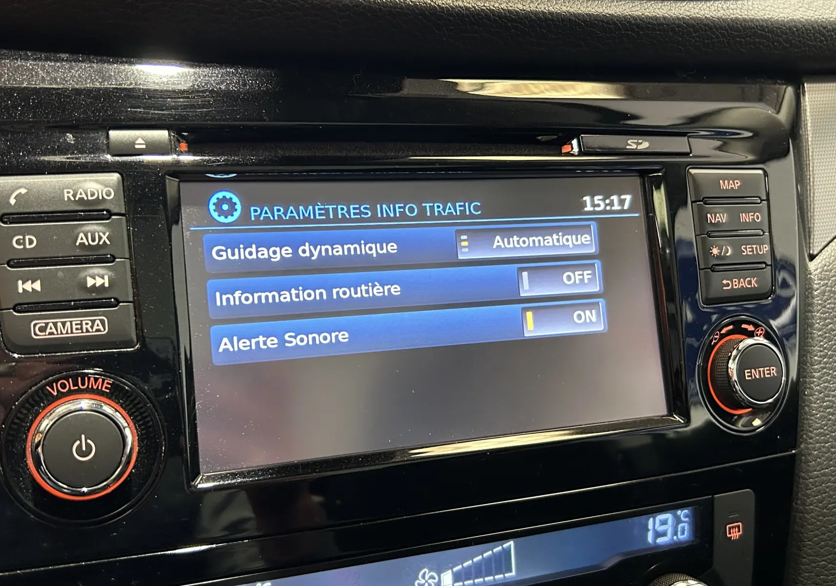 Écran central du tableau de bord du Nissan Qashqai blanc, affichant les paramètres de guidage dynamique et alertes sonores.