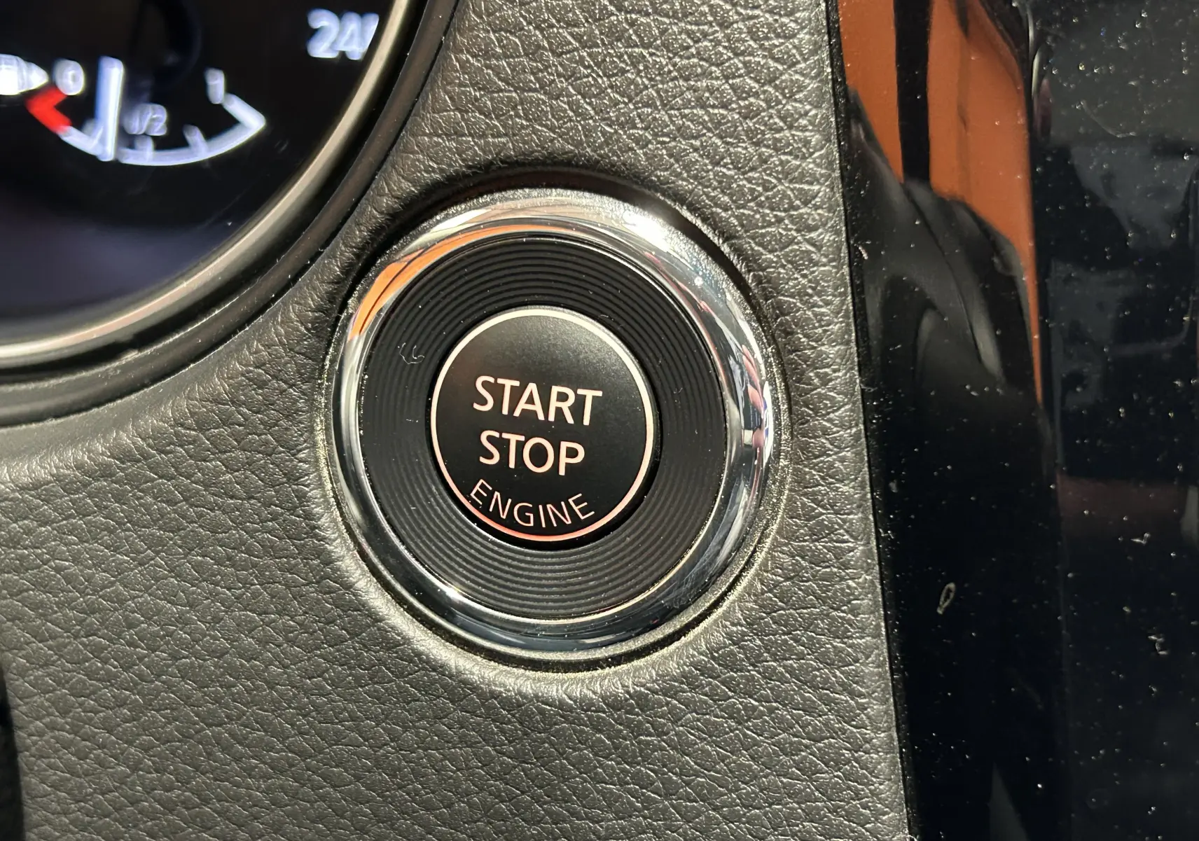 Gros plan sur le bouton Start Stop Engine entouré de chrome dans l’habitacle noir texturé du Nissan Qashqai.