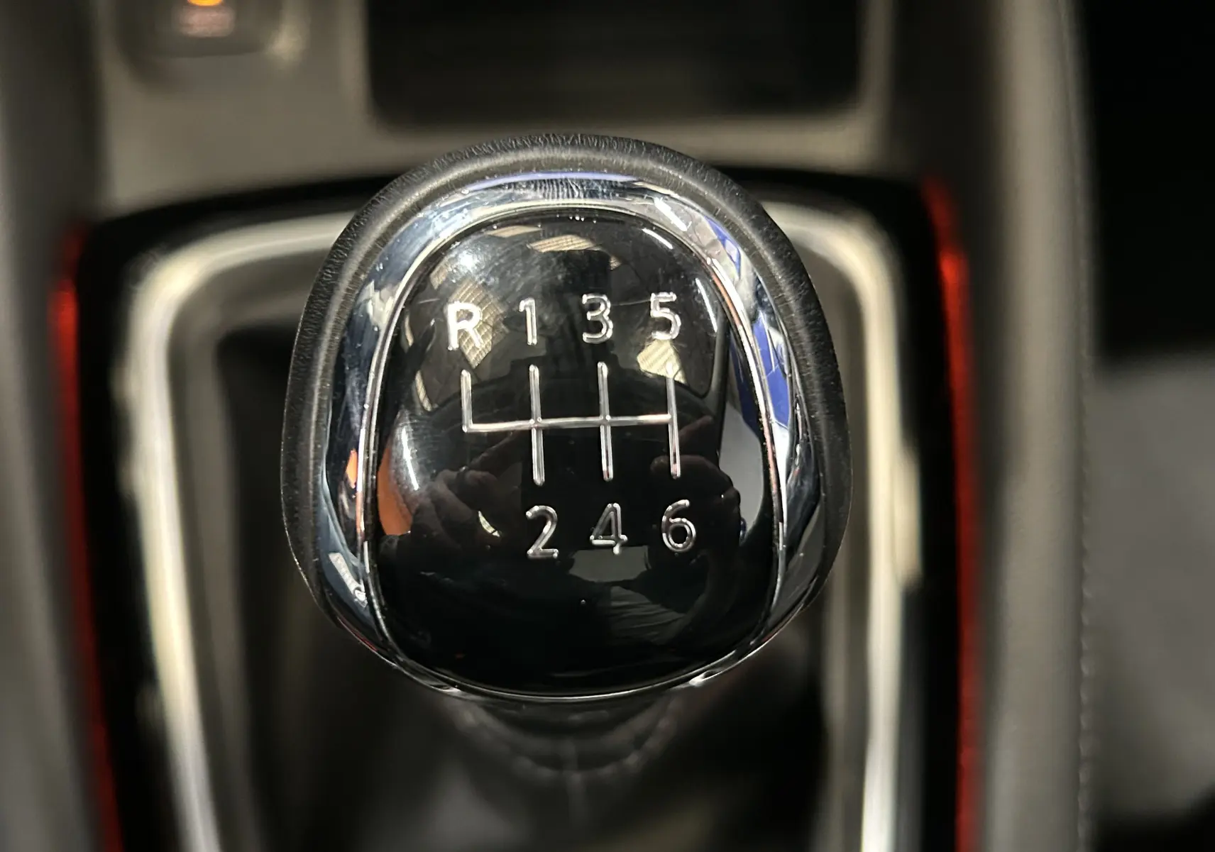 Gros plan sur le levier de vitesses manuel noir et chrome du Nissan Qashqai blanc, montrant les six rapports et la marche arrière.