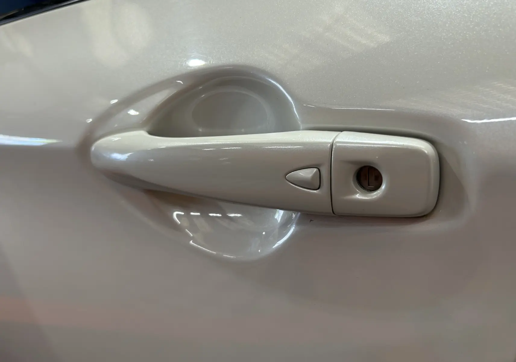 Poignée de porte côté gauche blanche du Nissan Qashqai 1.6 dCi 130 N-Connecta 2018 vue en gros plan.