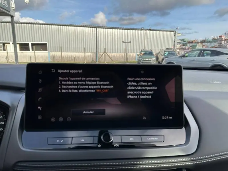 Vue intérieure centrée sur l'écran tactile du tableau de bord du Nissan Qashqai Hybrid e-POWER 2025, avec affichage Bluetooth.