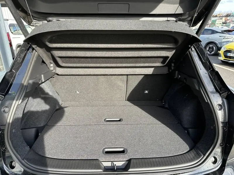 Coffre ouvert vu de l'arrière du Nissan Qashqai Hybrid e-POWER 205ch N-Connecta noir Kuro métallisé, espace de chargement vide.