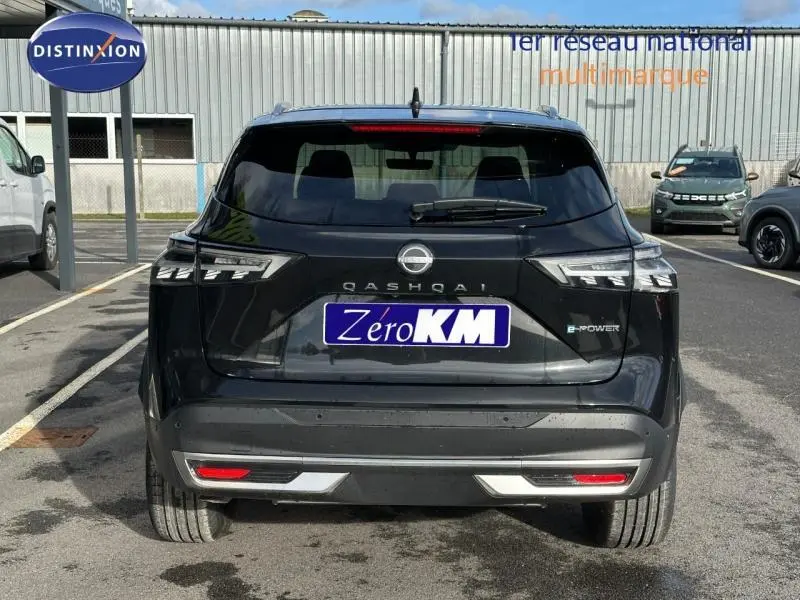 Vue arrière d'un Nissan Qashqai Hybrid e-POWER 2025 noir Kuro métallisé avec logo et feux LED distinctifs.