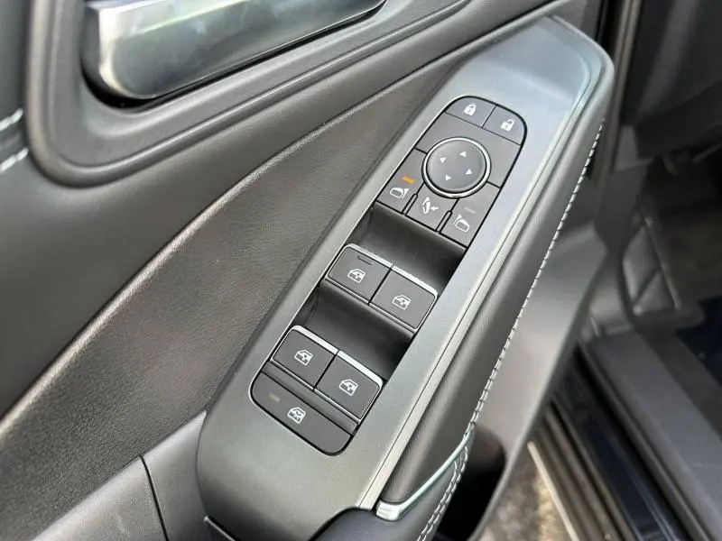 Gros plan sur les commandes des vitres et rétroviseurs côté conducteur du Nissan Qashqai Hybrid e-POWER 2025, intérieur noir.