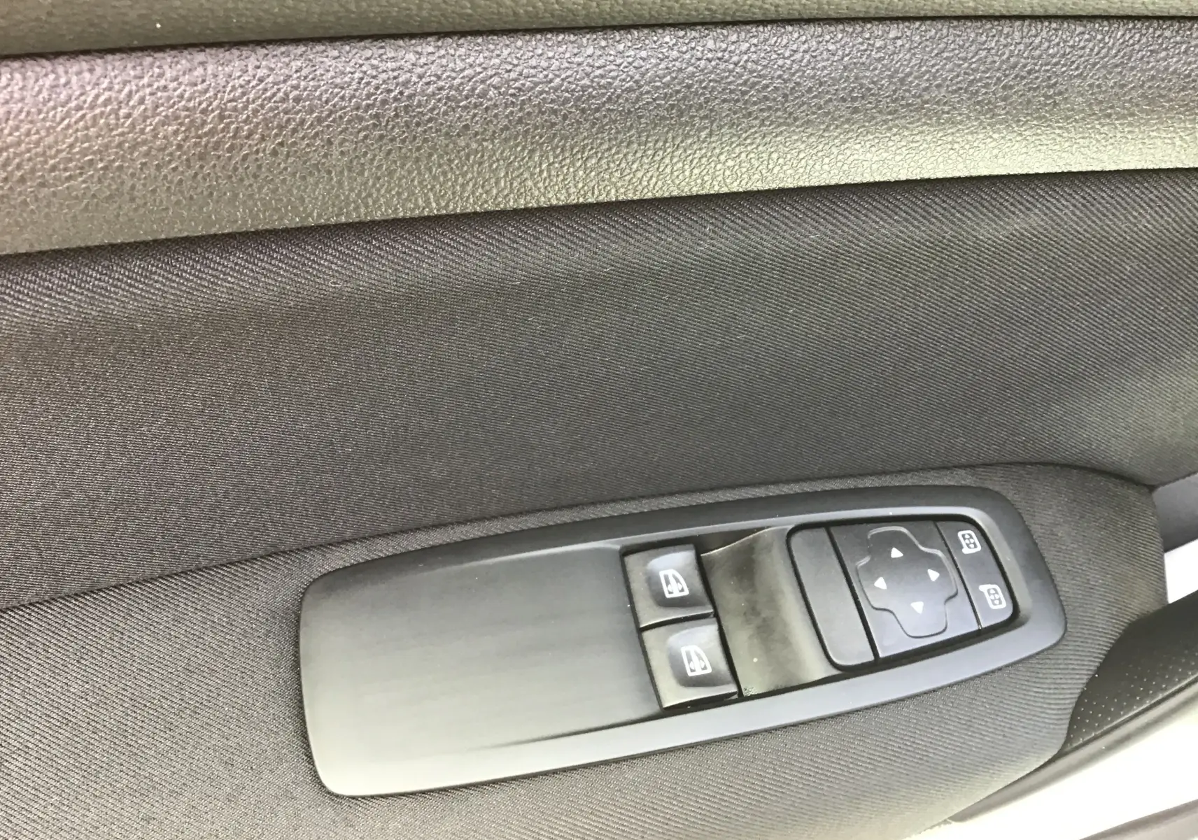 Commande des vitres électriques et réglage des rétroviseurs sur la porte intérieure côté conducteur d'une Renault Mégane IV Société blanche.