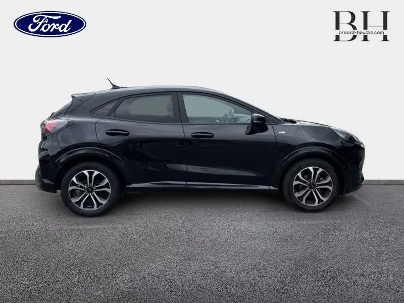 Profil droit d'un Ford Puma 2023 noir agate métallisé avec vitres arrière surteintées et jantes alliage distinctives.