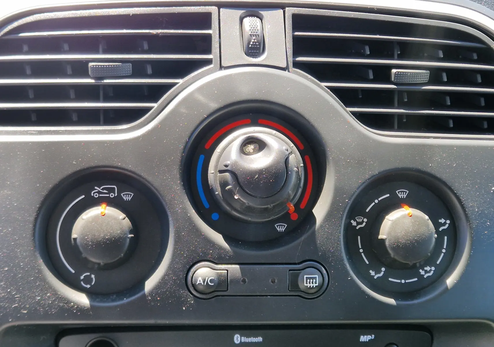 Gros plan sur la console centrale du Renault Kangoo blanc, montrant le bouton ECO et la prise allume-cigare ouverte.