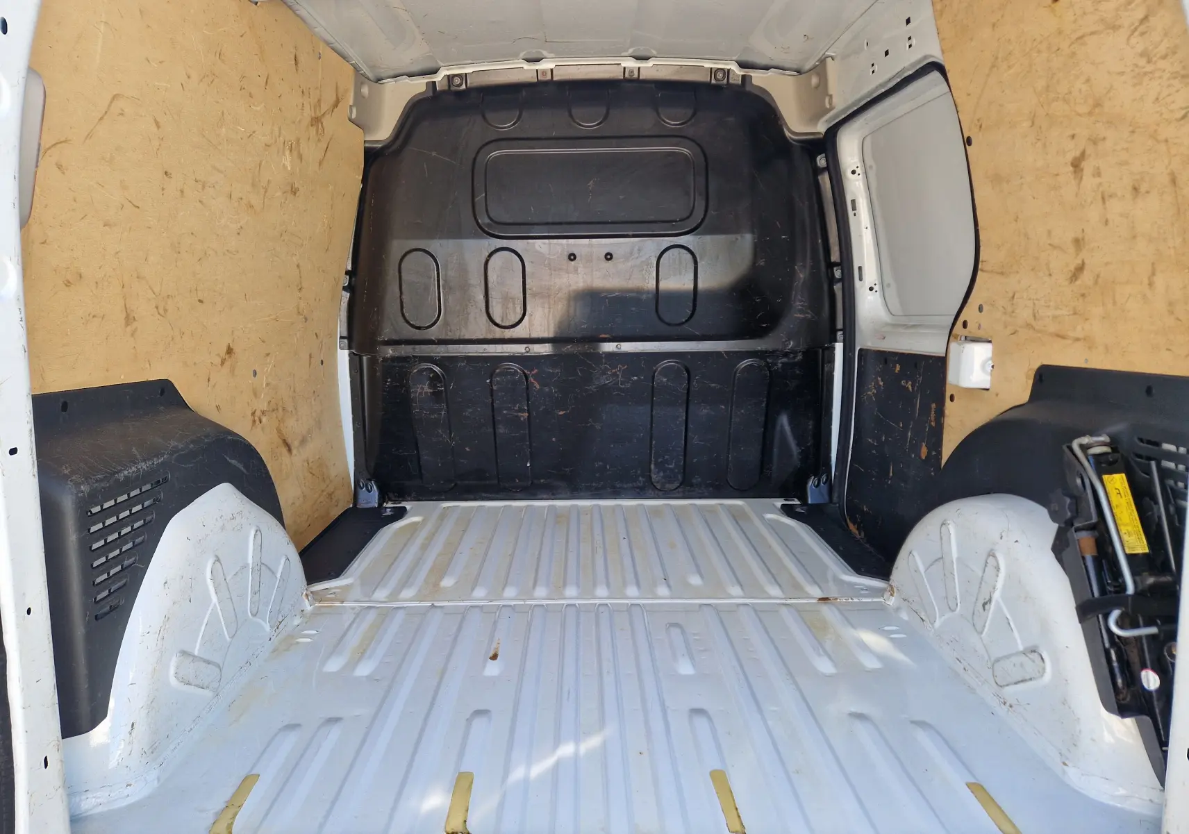 Vue arrière d’un Renault Kangoo blanc 2021, fourgon compact avec portes battantes et logo visible sur un parking extérieur.